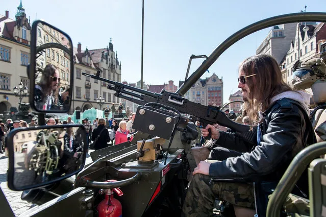 A man sits in a military vehicle during a meeting of soldiers of NATO multinational battalion battle group with residents at the Market Square in Wroclaw, Poland, 27 March 2017. US and British soldiers of the North Atlantic Treaty Organization (NATO) Enhanced Forward Presence (eFP) contingent are on their way from Germany to Orzysz, north Poland, where they will be stationed as part of reinforcement NATO's eastern flank. The military squad will present their military equipment and will meet with residents of Piotrkow Trybunalski and Warsaw. (Photo by Maciej Kulczynski/EPA)