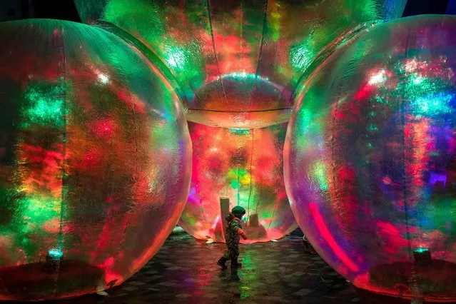A boy walks near light installation during the “Festival of Lights” celebrating the 699th anniversary of Vilnius city at the Palace of the Grand Dukes of Lithuania in Vilnius, Lithuania, Tuesday, January 25, 2022. Vilnius Light Festival, that covers the central part of the city, and has gained the recognition of countless visitors, invited guests and residents of the capital of Lithuania to celebrate the birthday of Vilnius city on the 25-29th of January 2022. (Photo by Mindaugas Kulbis/AP Photo)