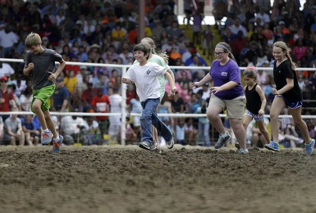 Children participate in a comedy event without animals at the Angola Prison Rodeo in Angola, La., Saturday, April 26, 2014. In a half-century, the event has grown from a small event for prisoners into a big business that draws thousands of spectators to the Louisiana State Penitentiary. (Photo by Gerald Herbert/AP Photo)