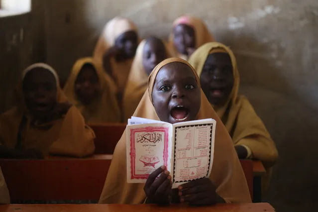 A girl wearing hijab recites Islamic texts from a book in a school in Maiduguri, north-eastern Borno state, Nigeria, 07 February 2022. The Nigeria’s northeast has been a zone of terrorism over the past 12 years, with millions of people displaced, and many living in IDP camps, over the activities of the Islamic terrorists who are angered by formal, Western education. Normal daily life is gradually returning to Maiduguri, the epicenter of the crisis. (Photo by Akintunde Akinleye/EPA/EFE)