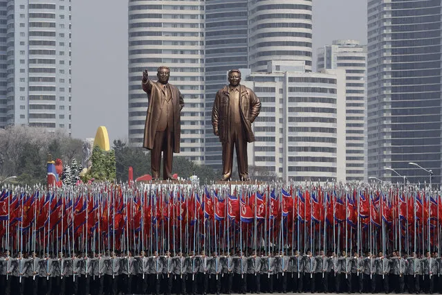 University students carry the national flag and two bronze statues of the late leaders Kim Il Sung and Kim Jong Il during a military parade on Saturday, April 15, 2017, in Pyongyang, North Korea, to celebrate the 105th birth anniversary of Kim Il Sung, the country's late founder and grandfather of current ruler Kim Jong Un. (Photo by Wong Maye-E/AP Photo)