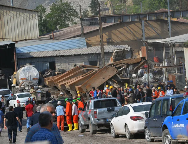 Rescue workers at the entrance of the mine after an explosion and fire at a coal mine in Soma, in western Turkey, Tuesday, May 13, 2014.  An explosion and fire at a coal mine in western Turkey killed at least one miner Tuesday and left up to 300 workers trapped underground, a Turkish official said. (Photo by AP Photo/IHA)
