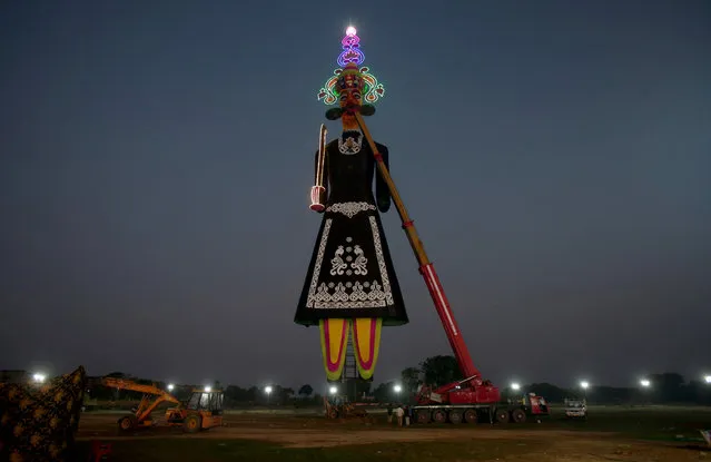 A 221-feet long effigy of the demon king Ravana is installed early morning in a ground during preparations for the upcoming Hindu festival of Dussehra or Vijaya Dashami, on the outskirts of Chandigarh, India, October 3, 2019. (Photo by Ajay Verma/Reuters)