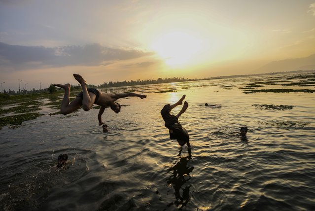 Kashmiri boys jump into the Dal Lake during a hot summer day in Srinagar, Indian controlled Kashmir, Tuesday, July 2, 2024. (Photo by Mukhtar Khan/AP Photo)