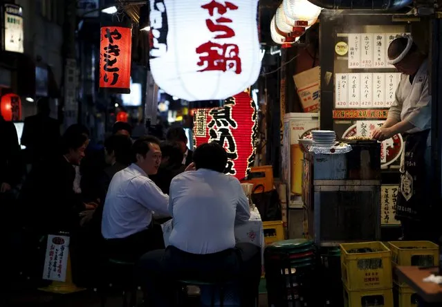 People sit on stools outside a Japanese pub-style restaurant at a business district in Tokyo, Japan, April 30, 2015. (Photo by Yuya Shino/Reuters)