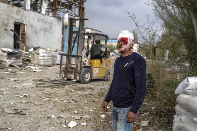 An injured man looks on following a Russian bombing of a factory in Kramatorsk, in eastern Ukraine, on Tuesday, April 19, 2022. Russian forces attacked along a broad front in eastern Ukraine on Tuesday as part of a full-scale ground offensive to take control of the country's eastern industrial heartland in what Ukrainian officials called a “new phase of the war”. (Photo by Petros Giannakouris/AP Photo)