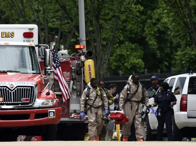 Men in what appears to be a hazardous materials suits by the Northwest gate of the White House in Washington, Monday, May 30, 2016. (Photo by Susan Walsh/AP Photo)