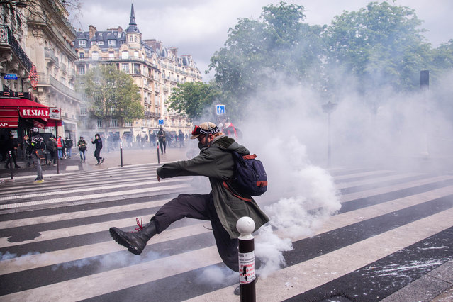 Demonstrators hold banners and flags as they protest on International Workers' day against the government's pension reform in Paris, France on May 1, 2023. French riot police took position during a protest. (Photo by Ibrahim Ezzat/Anadolu Agency via Getty Images)