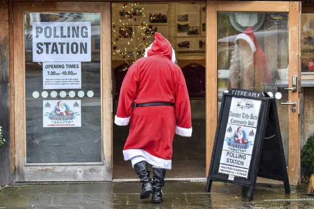 A man dressed as Father Christmas enters his grotto at the Dunster Tithe Barn near Minehead, Somerset, England which is being used as a polling station in the 2019 general election, Thursday December 12, 2019. Britain is holding an early election in wintry December, with a number of strange locations put in use as polling places. Among the places where Britons cast their ballots Tuesday were a car dealership, a laundrette, a Christmas grotto and of course some pubs. There were a few problems, including flooding at one location. (Photo by Ben Birchall/PA Wire via AP Photo)