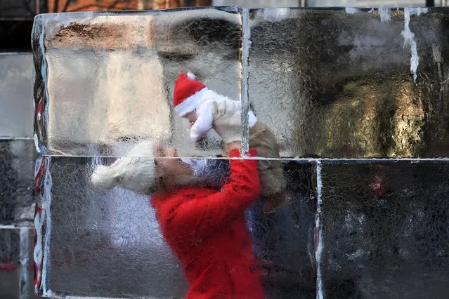 Brandy Wendler of Alexandria holds up her son, Ronin Wendler, four months, as they visit the Ice Maze at CityCenterDC in Washington on December 15, 2019. (Photo by Matt McClain/The Washington Post)