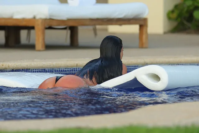 Kim Kardashian, wearing a skimpy black bikini, takes a plunge in the pool as she enjoys a second honeymoon in Mexico with Kanye West. The newly-weds stayed at the exclusive home of Girls Gone Wild founder Joe Francis, after jetting in to Punta Mita, to catch some pool side relaxation - and celebrate Kanye's 37th birthday. The Wests honeymooned in Ireland and Prague after their May 24 wedding in Italy. Photos June 15,2014. (Photo by Brian Prahl/Splash News)