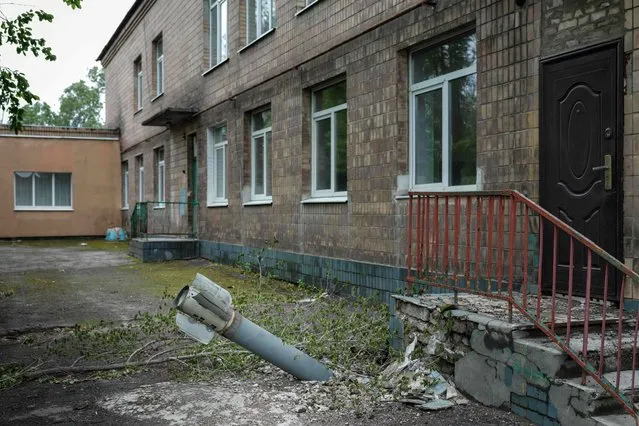 An unexploded ordnance is seen at a backdoor of a kindergarten where seven people have been sheltering in the basement for more than two months, in Lysychansk, eastern Ukraine, on May 14, 2022. Intense fighting raged in eastern Ukraine's Donbas region on May 14, 2022, where Russia has been concentrating its forces without making significant progress, while “very difficult negotiations” were under way over the fate of the last besieged defenders in the city of Mariupol. Russia invaded Ukraine on February 24, 2022. (Photo by Yasuyoshi Chiba/AFP Photo)