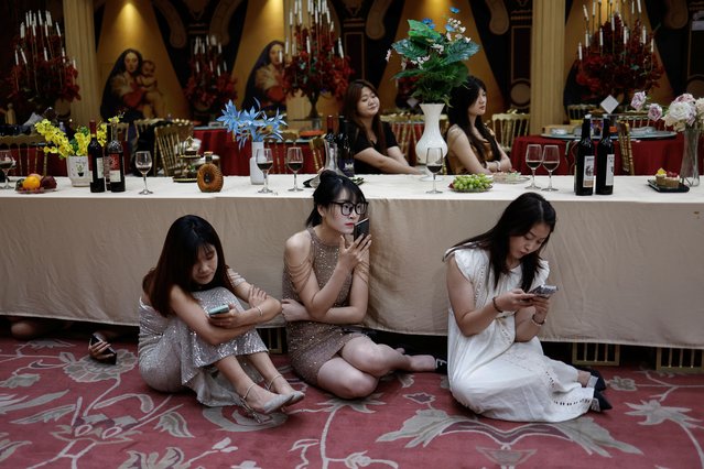 Actors wait on the set of a micro movie during a filming session at a banquet hall, in Zhengzhou, Henan province, China on July 16, 2024. (Photo by Tingshu Wang/Reuters)