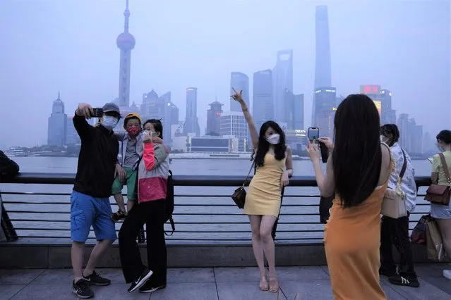 Residents pose for photos along the bund, Wednesday, June 1, 2022, in Shanghai. (Photo by Ng Han Guan/AP Photo)