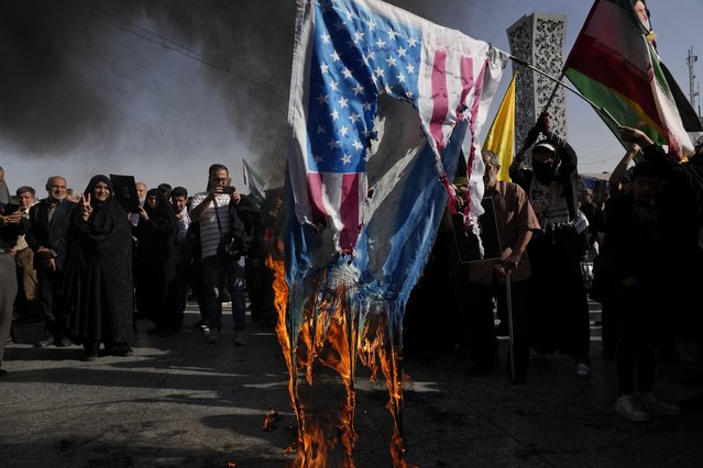 Demonstrators burn representations of the U.S. and Israeli flags in a rally commemorating slain Hezbollah leader Hassan Nasrallah, in Tehran, Iran, Wednesday, October 2, 2024. (Photo by Vahid Salemi/AP Photo)