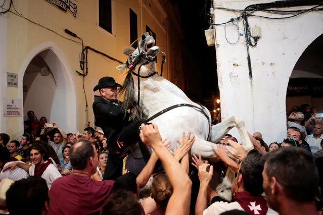 A rider rears up on his horse while surrounded by a cheering crowd during the traditional Fiesta of Sant Joan (Saint John) in downtown Ciutadella, on the island of Menorca, Spain June 23, 2016. (Photo by Enrique Calvo/Reuters)