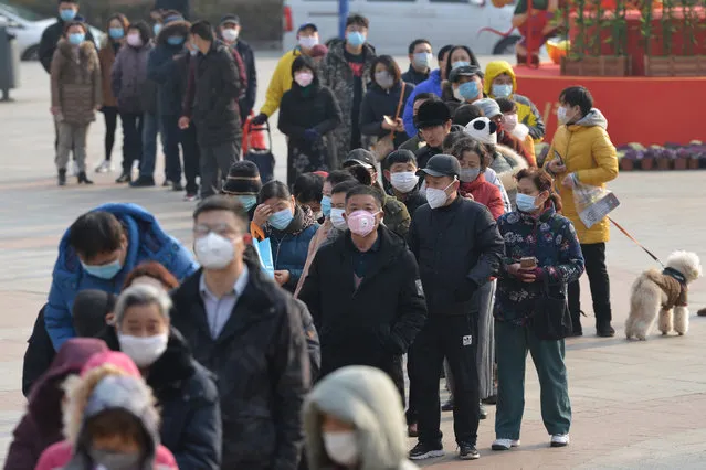 People line up outside a drugstore to buy medical masks in Nanjing, Jiangsu province, China, 29 January 2020. According to media reports, coronavirus, which in severe cases causes pneumonia, killed 132 people and infected nearly 6,000, mainly in China. Governments around the world are taking preventative measures to health the spread of the virus. (Photo by Fang Dongxu/EPA/EFE)