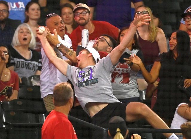An Arizona Diamondbacks fan catches a foul ball during the seventh inning against the Cincinnati Reds at Chase Field on June 14, 2022 in Phoenix, Arizona. (Photo by Norm Hall/Getty Images)