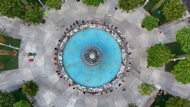 This aerial view shows people holding hands at a memorial event marking the one-year anniversary of the Hamas attack in southern Israel, in Tel Aviv, on October 7, 2024. Israel began its commemorations of the one-year anniversary of Hamas's deadly October 7 attack, with an outpouring of emotion at vigils at massacre sites and rallies calling for the return of hostages. (Photo by Jack Guez/AFP Photo)