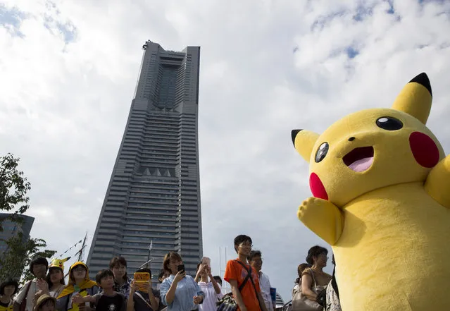 People take photographs of a performer dressed as Pikachu, a character from Pokemon series game titles, during the Pikachu Outbreak event hosted by The Pokemon Co. on August 9, 2017 in Yokohama, Kanagawa, Japan. (Photo by Tomohiro Ohsumi/Getty Images)