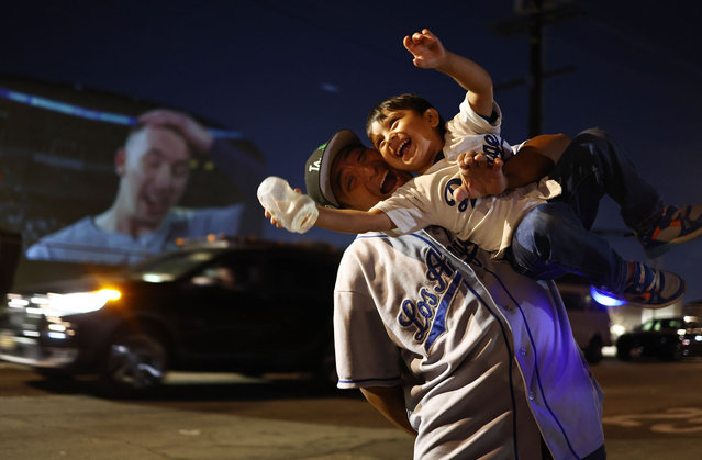 Misael Morales celebrates with his son Sebastian in East L.A. after the Los Angeles Dodgers defeated the New York Yankees 7-6 in Game 5 to win the World Series on October 30, 2024 in Los Angeles, California. Morales projected the game onto a water tower from his home for members of the community. (Photo by Mario Tama/Getty Images)