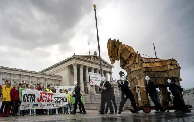Activists of Attac, Global2000, OeVB, Proge, Suedwind and Greenpeace participate in a protest against CETA (Comprehensive Economic and Trade Agreement) between EU and Canada in front of the empty Austrian Parliament building  in Vienna, Austria on September 20, 2017. For the first time, the Parliament session was held today at the Hofburg palace, as the Parliament building is under a reconstruction. (Photo by Joe Klamar/AFP Photo)