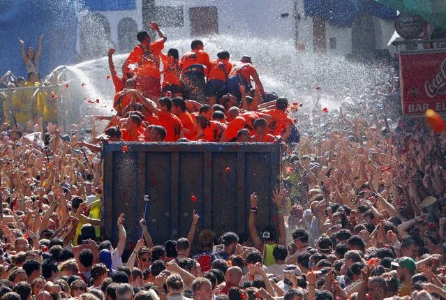 Crowds of people throw tomatoes at each other, during the annual “Tomatina” tomato fight fiesta, in the village of Bunol, 50 kilometers outside Valencia, Spain, Wednesday, August 27, 2014. (Photo by Alberto Saiz/AP Photo)