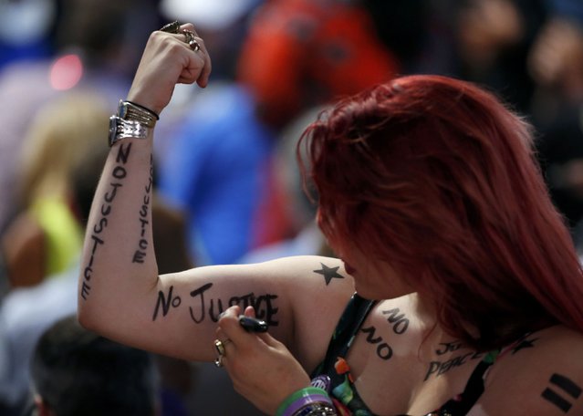 An attendee writes a slogan on her arm during the Democratic National Convention in Philadelphia, Pennsylvania, U.S. July 26, 2016. (Photo by Lucy Nicholson/Reuters)