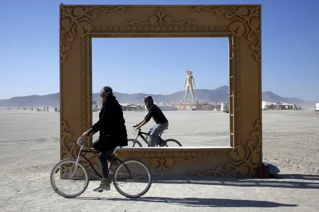 Participants ride around the art installation “Got Framed” during the Burning Man “Carnival of Mirrors” arts and music festival in the Black Rock Desert of Nevada, September 4, 2015. (Photo by Jim Urquhart/Reuters)