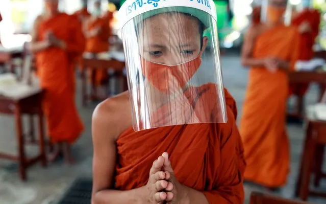 Buddhist novice monks wearing face shields and protective face masks attend a lesson at Wat Molilokayaram monastic educational institute during coronavirus disease (COVID-19) outbreak in Bangkok, Thailand on April 22, 2020. (Photo by Soe Zeya Tun/Reuters)