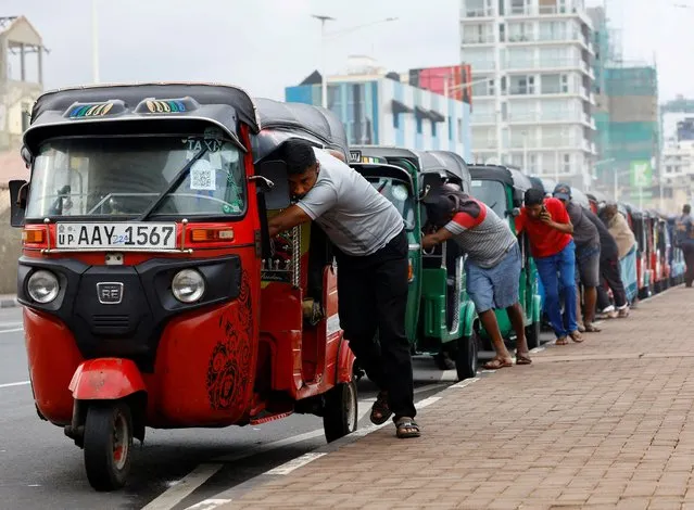 Drivers push auto rickshaws in a line to buy petrol from a fuel station, amid Sri Lanka's economic crisis, in Colombo, Sri Lanka on July 29, 2022. (Photo by Kim Kyung-Hoon/Reuters)