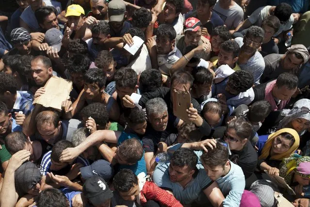 Refugees and migrants are packed together while waiting for a registration procedure at the port of Mytilene on the Greek island of Lesbos, September 5, 2015. (Photo by Dimitris Michalakis/Reuters)