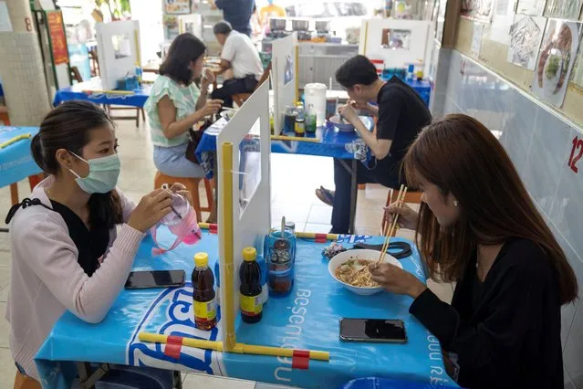 People have lunch in a noodle restaurant that reopened after the easing of restrictions with the implementation of a plastic barrier and social distancing measures to prevent the spread of the coronavirus disease (COVID-19) in Bangkok, Thailand, May 6, 2020. (Photo by Athit Perawongmetha/Reuters)