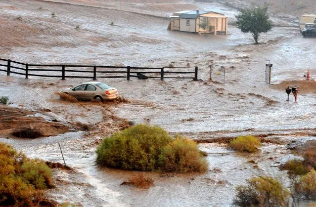 A vehicle crosses a flooded section of Carob Street, Tuesday, September 8, 2015, in Hesperia, Calif. The National Weather Service issued a flash flood warning and severe thunderstorm warning for the area on Tuesday night. (Photo by David Pardo/The Victor Valley Daily Press via AP Photo)