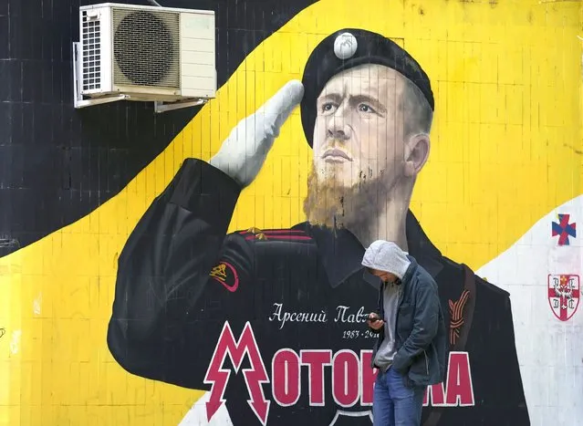A man passes by a mural depicting a senior commander of pro-Russia separatists in eastern Ukraine Arsen Pavlov, also known as Motorola, who was killed in Donetsk on 2016, on a wall in Belgrade, Serbia, Tuesday, September 20, 2022. The Kremlin said Tuesday that there are no prospects for a negotiated end to the war in Ukraine and gave its blessing to efforts to swiftly bring regions already captured under Russia's complete control. (Photo by Darko Vojinovic/AP Photo)