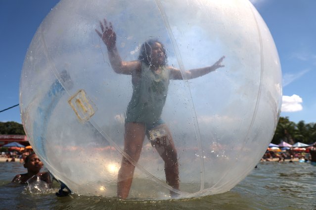 A child floats inside a plastic ball at an artificial pond known as Piscinao de Ramos, or big pool, in the northern suburbs of Rio de Janeiro, Brazil on February 9, 2025. (Photo by Aline Massuca/Reuters)