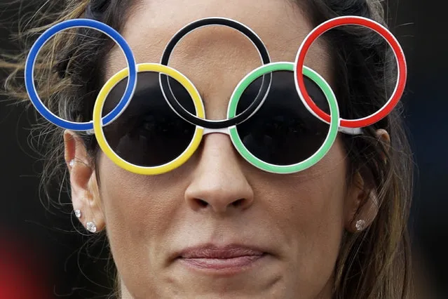 A woman wearing Olympic rings glasses smiles as she walks in Olympic Park at the 2016 Summer Olympics in Rio de Janeiro, Brazil, Monday, August 8, 2016. (Photo by Pavel Golovkin/AP Photo)