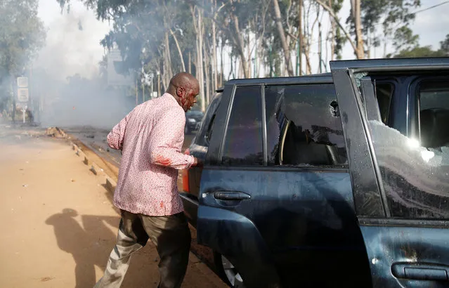 The driver to Kathiani Member of Parliament Robert Mbui secures his damaged car after he was hit by another vehicle as riot police dispersed the convoy of Kenyan opposition leader Raila Odinga of the National Super Alliance (NASA) coalition in Nairobi, Kenya on November 17, 2017. (Photo by Thomas Mukoya/Reuters)