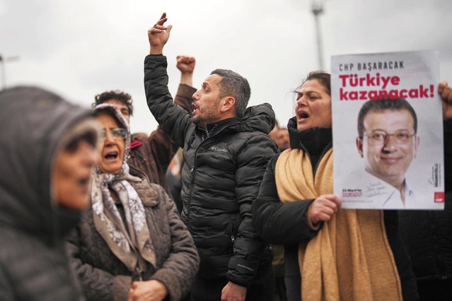 People chant slogans and hold posters of Istanbul Mayor Ekrem Imamoglu as they protest outside the Vatan Security Department, where Imamoglu is expected to be taken following his arrest in Istanbul, Turkey, Wednesday, March 19, 2025. (Photo by Francisco Seco/AP Photo)