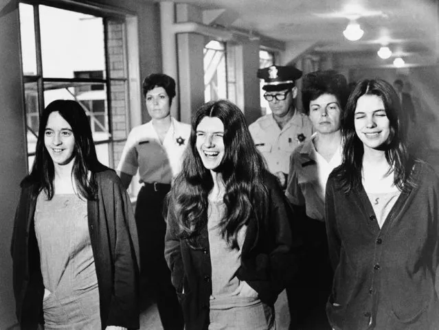 Three female defendants in the Sharon Tate murder trial burst out laughing as they come within range of news cameras en route to court in Los Angeles, August 11, 1970.  Left to right: Susan Denise Atkins, Patricia Krenwinkel, Leslie Van Houten. (Photo by AP Photo)
