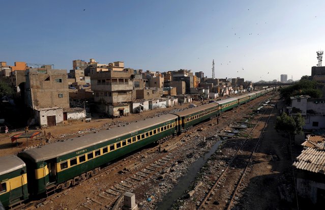 A passenger train moves past a slum area as the outbreak of the coronavirus disease (COVID-19) continues, in Karachi, Pakistan on July 9, 2020. (Photo by Akhtar Soomro/Reuters)