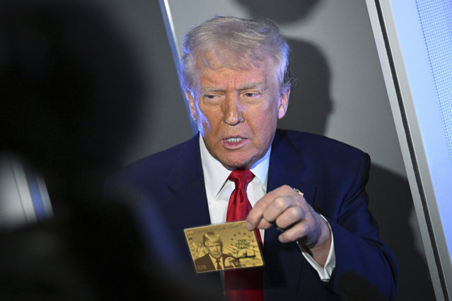 President Donald Trump holds up the $5 million gold card as he speaks to reporters while in flight on board Air Force One, en route to Miami, Thursday, April 3, 2025. (Photo by Pool via AP Photo)