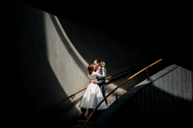 A newlywed couple kisses on the stairs of Andreyevsky Bridge in Moscow on July 7, 2020, amid the outbreak of COVID-19, caused by the novel coronavirus. (Photo by Dimitar Dilkoff/AFP Photo)