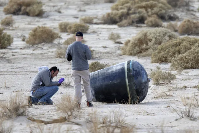 Investigators from the NTSB and Scale Composites inspect wreckage from the crash of Virgin Galactic's SpaceShipTwo near Cantil, California, on November 2, 2014. (Photo by David McNew/Reuters)