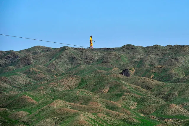 A man performs as he walks on a tightrope in Qingtongxia, Ningxia Hui Autonomous Region, China, August 26, 2016. (Photo by Reuters/Stringer)