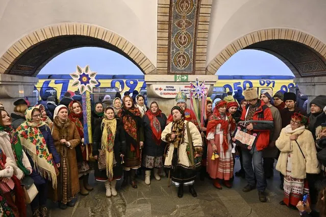 Local residents, dressed in traditional costumes, sing Christmas carols inside a metro station in Kyiv on December 25, 2022, amid the Russian invasion of Ukraine. (Photo by Sergei Chuzavkov/AFP Photo)