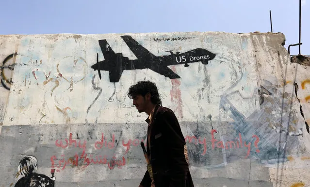 A Yemeni walks past graffiti protesting US drone operations in Yemen, few hours after a US drone attack on suspected al-Qaeda militants, Sana’a, Yemen, 05 September 2016. According to reports, a fresh round of US drone attacks on 05 September in Yemen led to the death of at least six suspected members of al-Qaeda in the Arabian Peninsula (AQAP) in Yemen's northeast province of Marib. (Photo by Yahya Arhab/EPA)