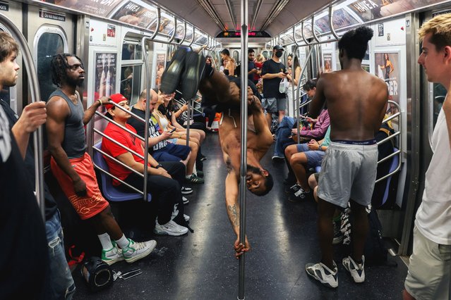 A man performs acrobatics on the subway in New York City, on June 6, 2025. (Photo by Kevin Coombs/Reuters)