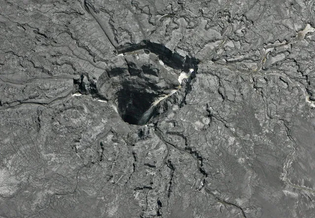 This aerial photo shows a massive sinkhole Friday, September 16, 2016, in Mulberry, Fla., that opened up underneath a gypsum stack at a Mosaic phosphate fertilizer plant. Tens of millions of gallons of reprocessed water from the fertilizer plant in central Florida are likely to have seeped into the Floridan aquifer after the massive sinkhole opened up. Mosaic says it's monitoring groundwater and has found no offsite impact. (Photo by Jim Damaske/Tampa Bay Times via AP Photo)