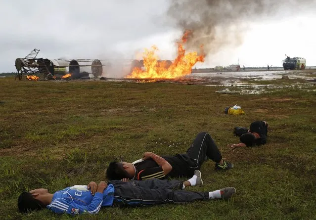 People take part in an air crash practice for Malaysia Airports to test their Airport Emergency Procedure at Kuala Lumpur International Airport (KLIA) in Sepang November 26, 2014. (Photo by Olivia Harris/Reuters)